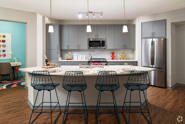 Kitchen with island and stainless steel appliances - The District at Rosemary Rental