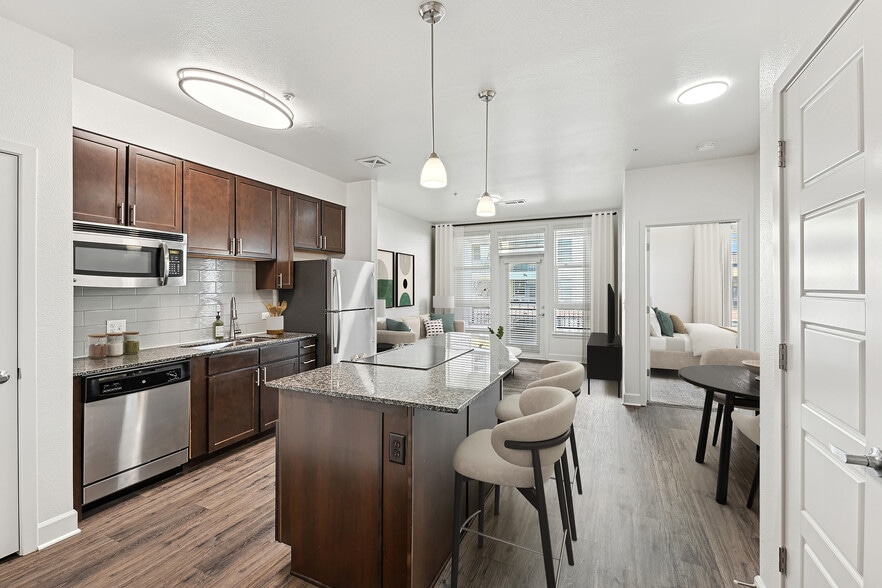 Refreshed Finishes kitchen with espresso cabinetry, speckled granite countertops, grey subway tile backsplash, stainless steel appliances, and hard surface flooring
