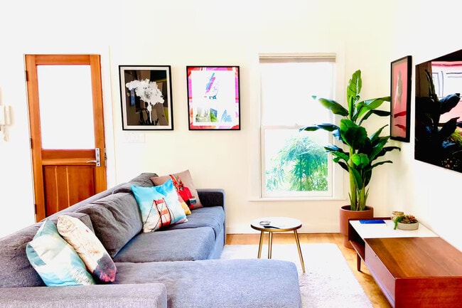 Large open living room & dining area w/ high ceilings, large windows, plenty of light, art, plants - 328 Harriet St
