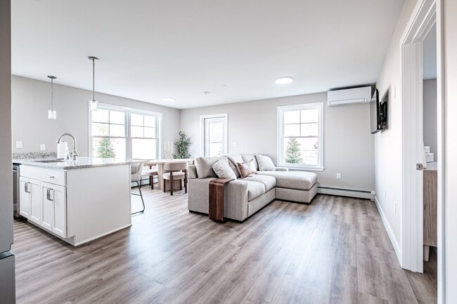 Enjoy bright, open-concept living with a seamless flow between the kitchen, dining, and living areas, enhanced by abundant natural light and modern finishes. - Windham Village Apartments