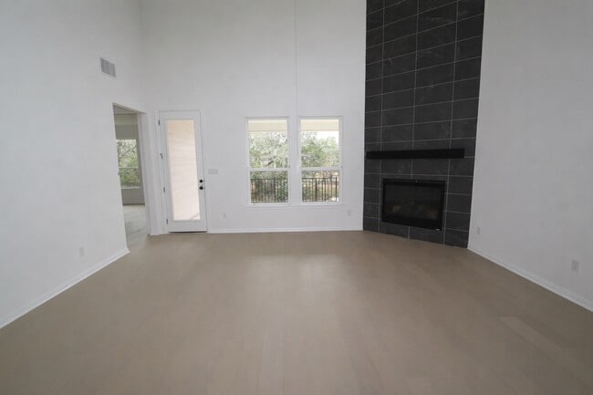 Spacious two-story living room with soaring ceilings, abundant natural light. - 517 Moonlit Stream Pass