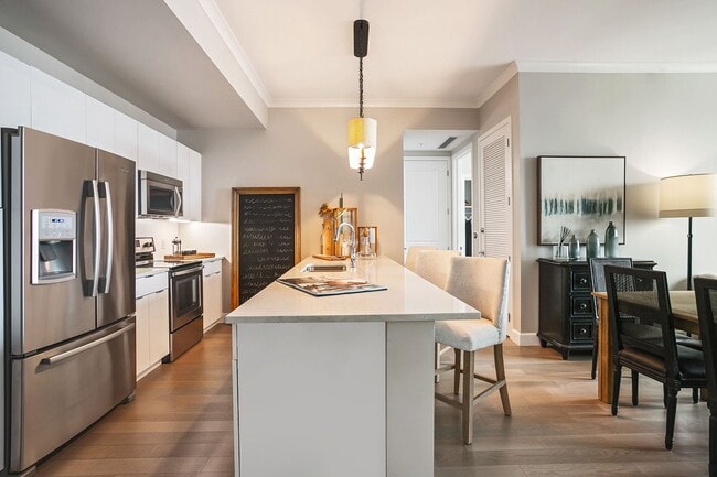 A chef-inspired kitchen featuring granite countertops, stainless steel appliances, and a spacious island for gathering - The Residence Buckhead Atlanta