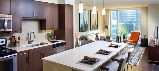 Classic Package I kitchen with espresso cabinetry, white quartz countertops, beige tile backsplash, stainless steel appliances, and hard surface flooring