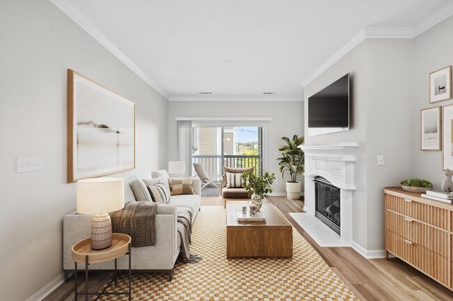 Living room with a fireplace in select homes, private balcony access, and abundant natural light that enhances everyday comfort and relaxation.