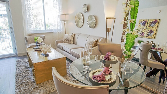 Luxury apartment living room with dining table, modern seating area, and large windows with natural light - Griffis North Olive