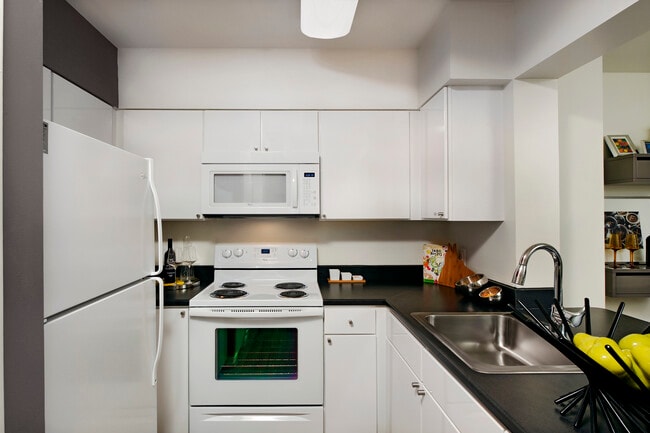 Classic Package kitchen with white cabinetry, white appliances and grey accent wall