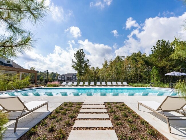 Our resort-style pool features in-pool seating for ultimate comfort and a spacious sundeck perfect for soaking up the rays. - Beckett West Fork Apartments