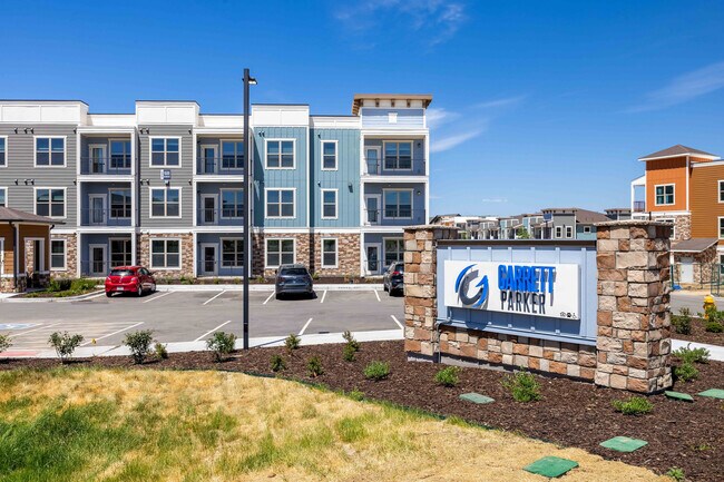 Un letrero de piedra marca la entrada a Garrett Parker, un complejo de apartamentos ubicado en 15511 Belford Avenue en Parker, CO.