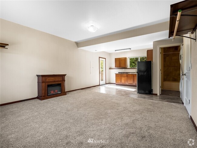 From back corner showing electric fireplace on the right, kitchen in the middle and washer and dryer - 10306 41st Trl SE Unit STUDIO Rental