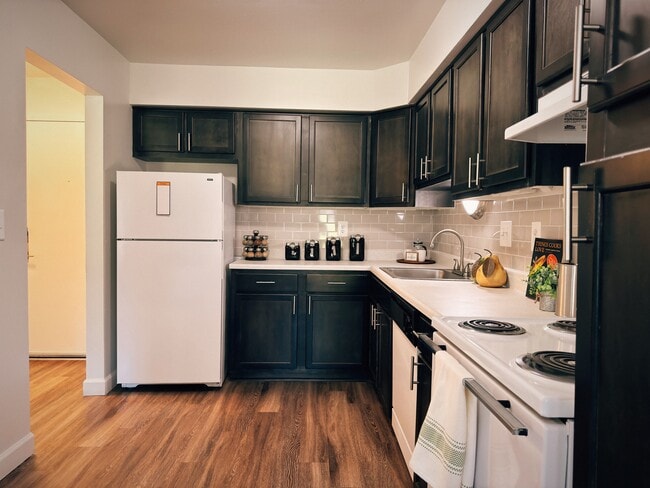 Cocina de espacio abierto con pisos de madera. - Maple Place Apartments