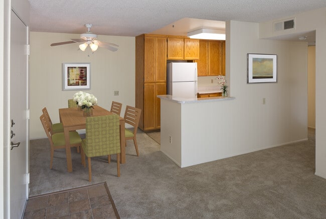 Classic Package kitchen with oak cabinetry, beige speckled laminate countertops, tile flooring, and white appliances