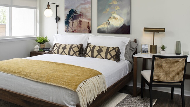 Spacious apartment bedroom with wood-style flooring.