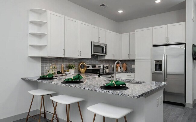 Diseño de cocina abierta con gabinetes blancos y electrodomésticos de acero inoxidable - The Harper