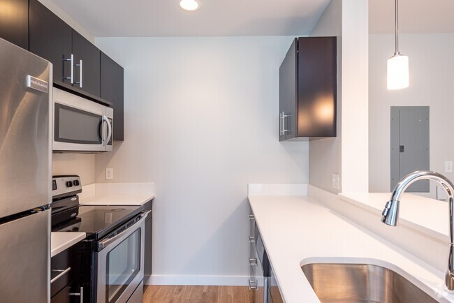 Please note that the countertops may vary by unit. While some feature lighter granite with a beige and brown pattern, others have a more white finish. - Renaissance Station North Rental