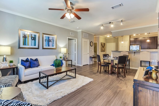 Large Living Room with open concept kitchen and ceiling fan and hard wood floors - Aspire Mckinney Ranch Apartments