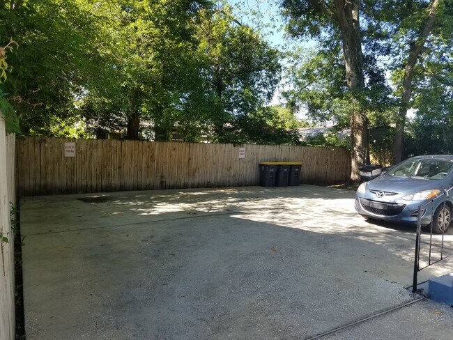 Concrete parking area behind the building that's well lighted. - 1564 W 14th St Apartment Unit 1