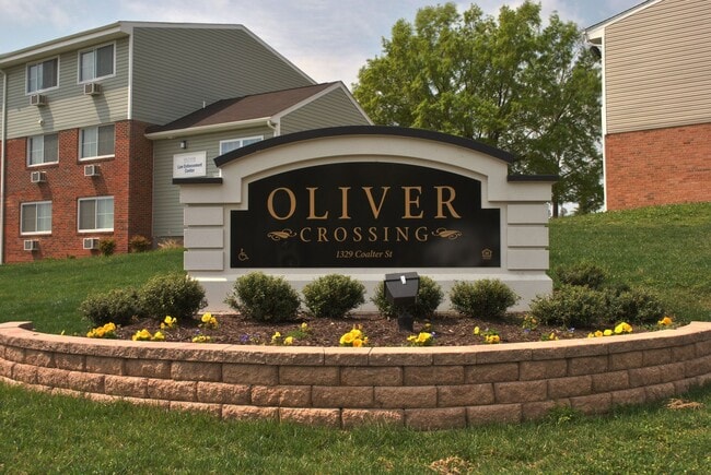 Oliver Crossing apartment community entrance sign with professionally landscaped grounds