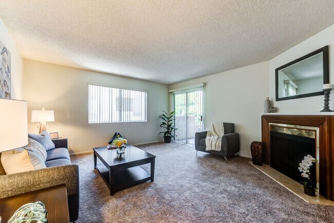 Amplia sala de estar con chimenea en el Plaza Apartments en Sherman Village