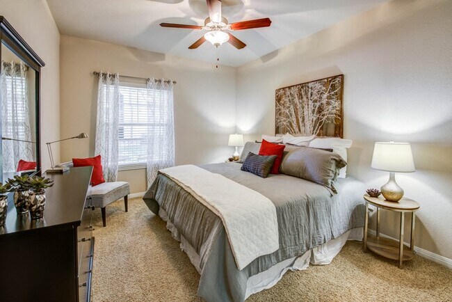 Spacious carpeted bedrooms with ceiling fan and natural light