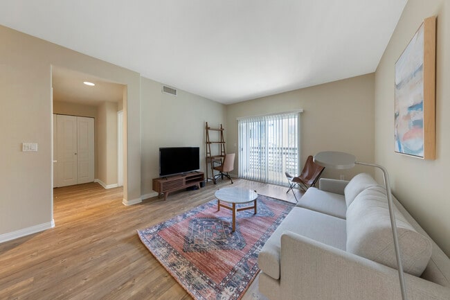 Furnished+ apartment homes come outfitted with a sofa, side chair, side table, coffee table, TV stand and 50" Television (Representative Image – exact items and style of furnishings may vary)