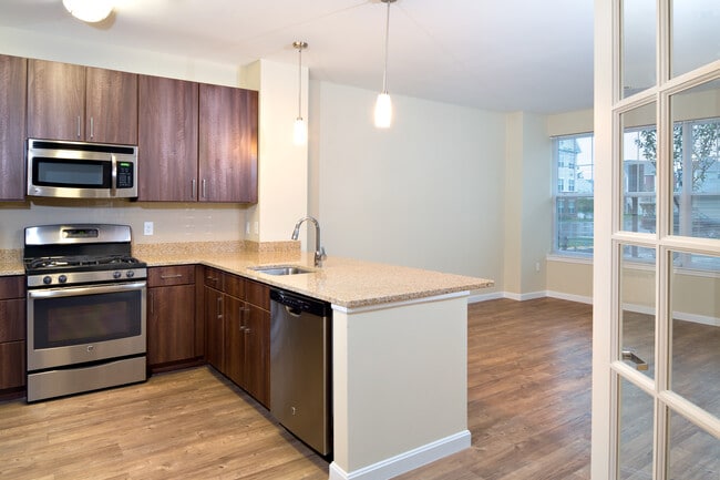Classic Kitchen with chocolate pecan cabinetry, tile backsplash, laminate countertops, hard surface flooring, and stainless steel appliances