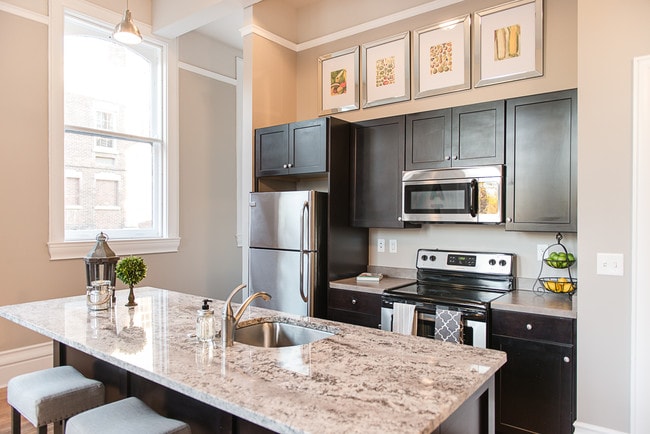 Typical Kitchen with Granite Counter Kitchen Island, Breakfast Bar, & Stainless Steel Appliances