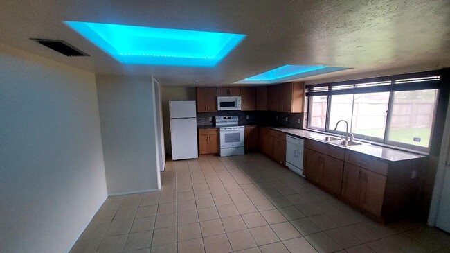 La cocina remodelada tiene iluminación ambiental - 5538 W Ridgecreek Dr Casa