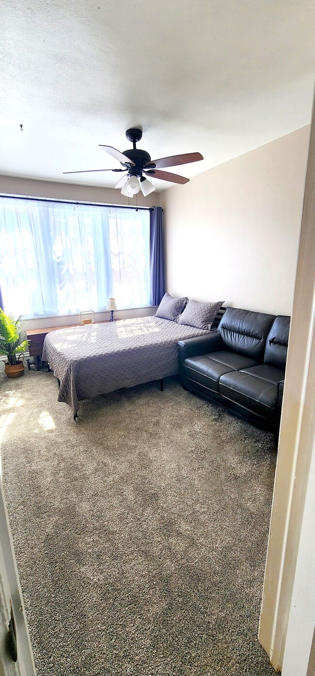 Primary Bedroom with Plush Queen Bed & Loveseat Bright and Inviting with Blackout Curtains - 822 E 4th St Unit #1