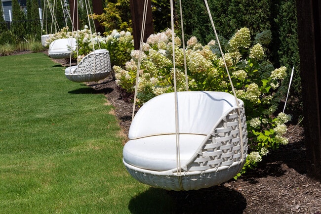Hanging swing chairs sit along the lawn, so an afternoon can slow down.