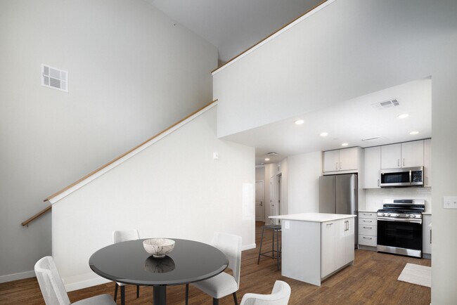Loft apartment with stainless steel appliances, white quartz countertops, light grey cabinetry, and hard surface flooring