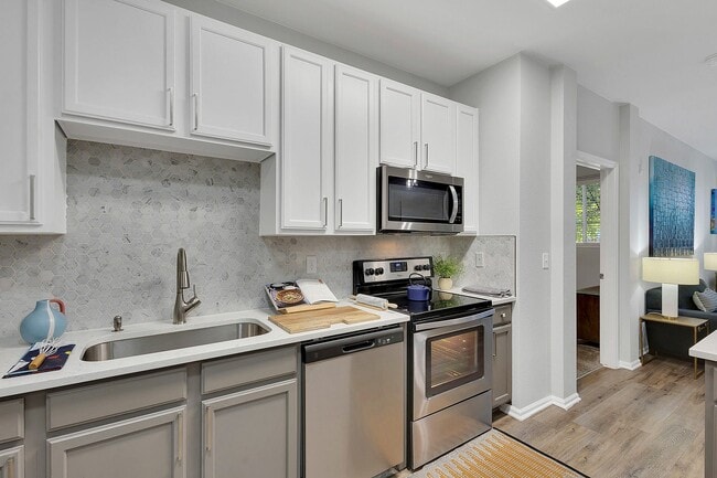 Modern kitchen with sleek appliances, elegant cabinetry, and stylish hexagonal backsplash, showcasing open-concept design.