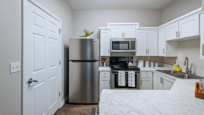 Fall in love with the newly remodeled kitchen, where stunning white marble-inspired countertops create a magical ambiance for your culinary adventures and a breakfast bar that opens to the living space for full enjoyment.