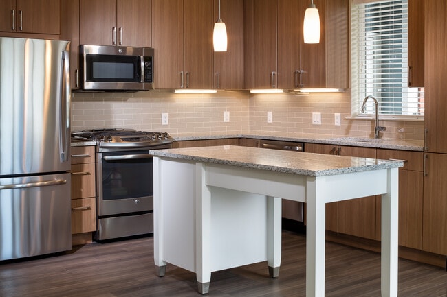 Traditional Collection Kitchen with oak cabinetry, beige tile backsplash, grey granite countertops, stainless steel appliances, and hard surface flooring