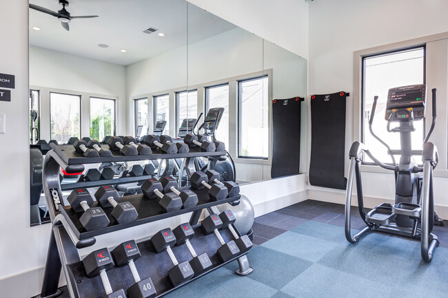 Club-quality fitness studio with free weights and elliptical. This image is a representation of the fitness studio at Amavi Brier Creek and is tentatively scheduled to open Summer 2025. - Amavi Brier Creek Homes