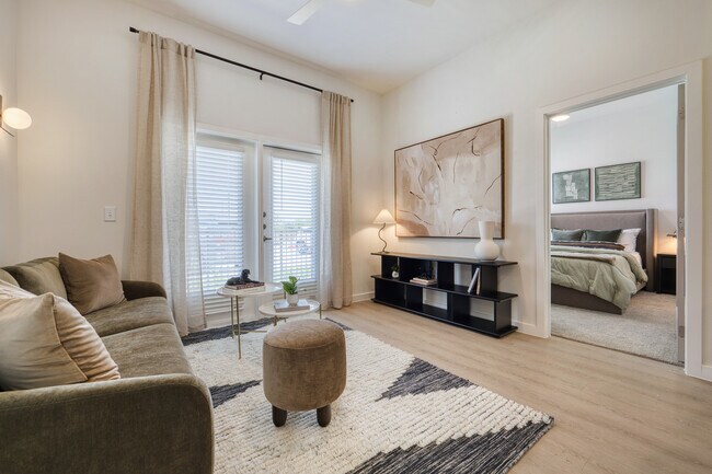 Bright living room with a ceiling fan and patio or balcony access at Sageland Flats at Brooks