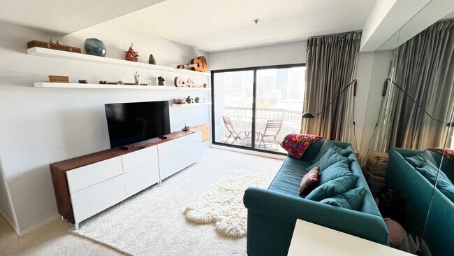 Living room - includes walnut counter and desk, shelving, lighting fixture, and window treatments - 601 Van Ness Ave Condo Unit 849