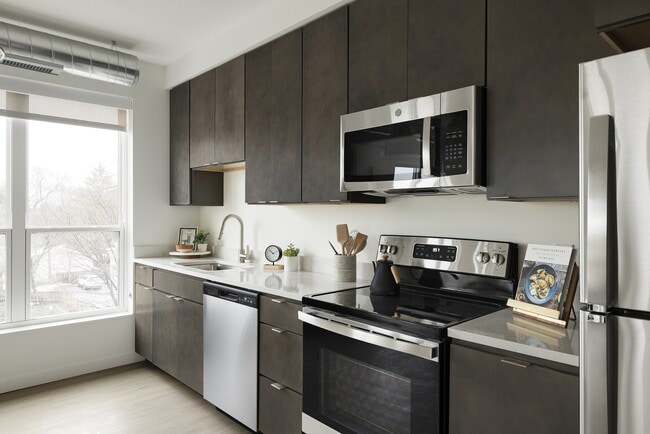 Rich cabinets, quartz counters, and modern fixtures complete this perfect and efficient kitchen setup