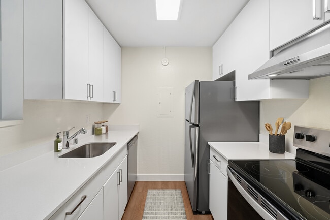 Renovated Package I with white cabinetry, white quartz countertops, stainless steel appliances, and hard surface flooring - eaves San Jose