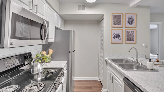 Our floor plans showcase galley-style kitchens with modern, pristine white cabinetry and stainless-steel appliances, creating a kitchen of grace and practicality. - River Bluff of Lexington Apartments