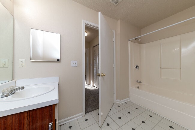 Baño luminoso con suelo de baldosas y bañera.