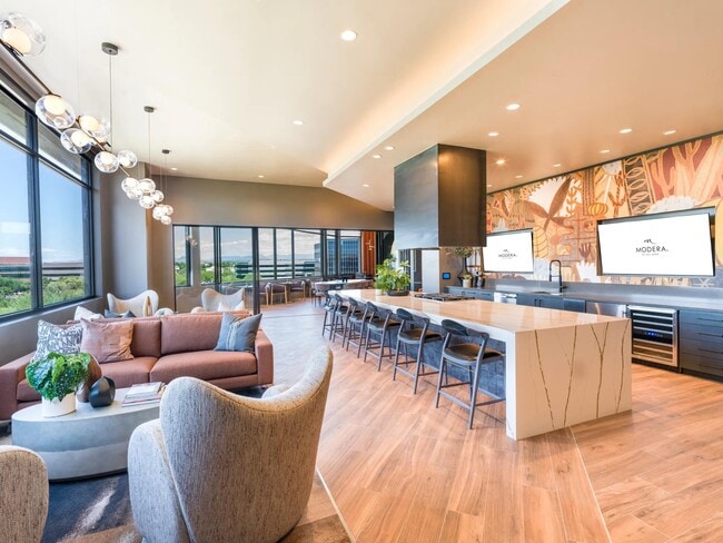 Host or unwind in the beautifully designed demonstration kitchen and lounge, featuring modern finishes, ample seating, and integrated entertainment displays. - Modera Reserve