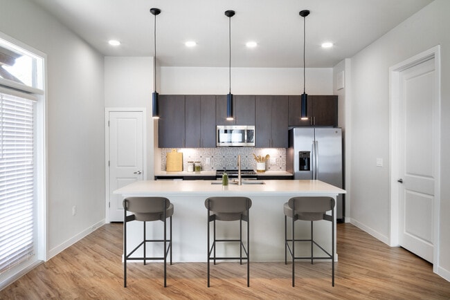 Kitchens with stainless steel appliances, wine fridges, quartz countertops, tile backsplash, and hard surface flooring
