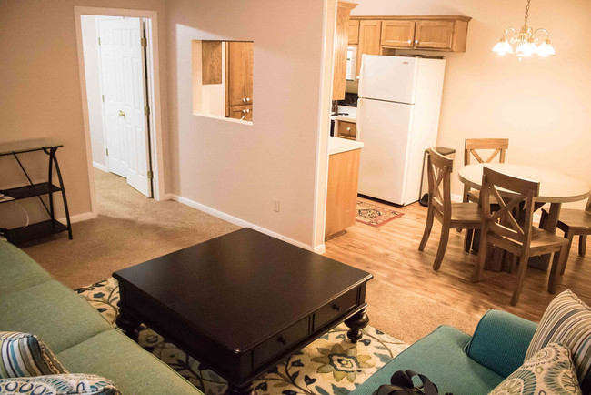 LIVING ROOM LOOKING INTO DINING ROOM AND KITCHEN. - Saddlebrook Manor Apartments