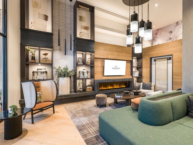 Relájese junto a la chimenea en este acogedor y moderno salón para residentes, perfecto para mañanas tranquilas o para relajarse con amigos. - Modera Falls Church