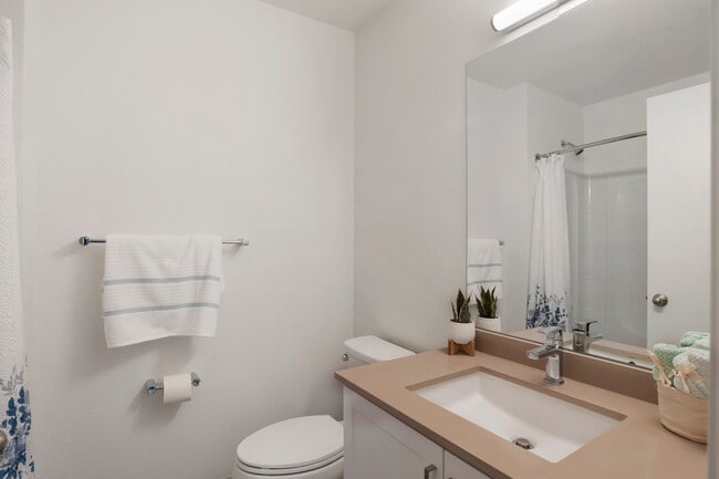 Baths with beige quartz countertops and white cabinetry