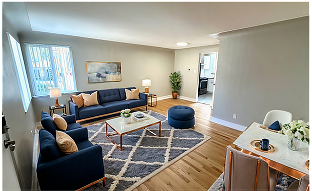 Chic and cozy apartment featuring a bright living area with plush seating and modern decor. Hardwood floors and large windows create an inviting atmosphere in this 1 bed, 1 bath unit for $1,350 per month. - Flats at 16th Rental