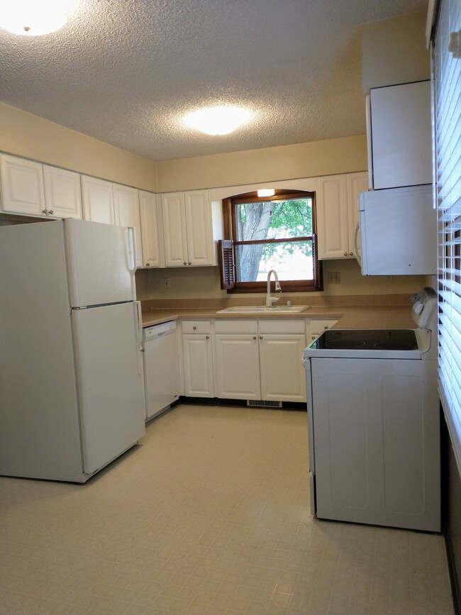 Large kitchen with eat-in dinette. Includes built-in microwave and garbage disposal. - 2024 64th St Townhome