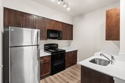 Enjoy a sleek, modern kitchen featuring stainless steel appliances, rich wood cabinetry, and bright countertops.