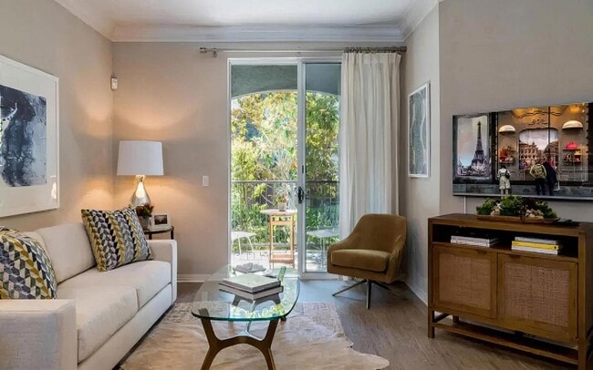 Sala de estar con acceso a balcón privado y luz natural. - Amerige Pointe