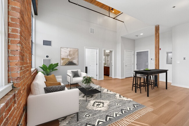 Modern loft apartment kitchen with stainless steel appliances, quartz countertops, and open layout
